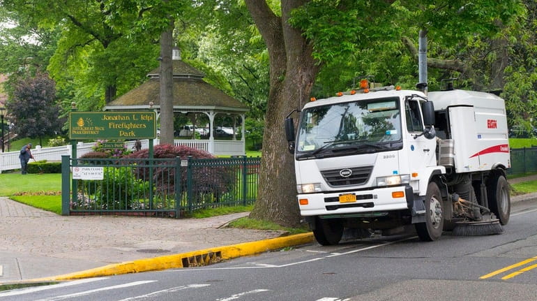 A Village of Great Neck Plaza street sweeper rides along...