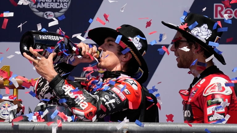 Winner Maverick Vinales, left, of Spain, celebrates with third-place finisher...