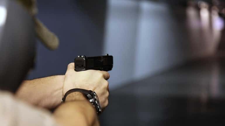 A man fires a handgun at Sandy Springs Gun Club...