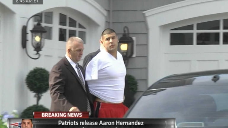 In this image taken from video, police escort Aaron Hernandez...