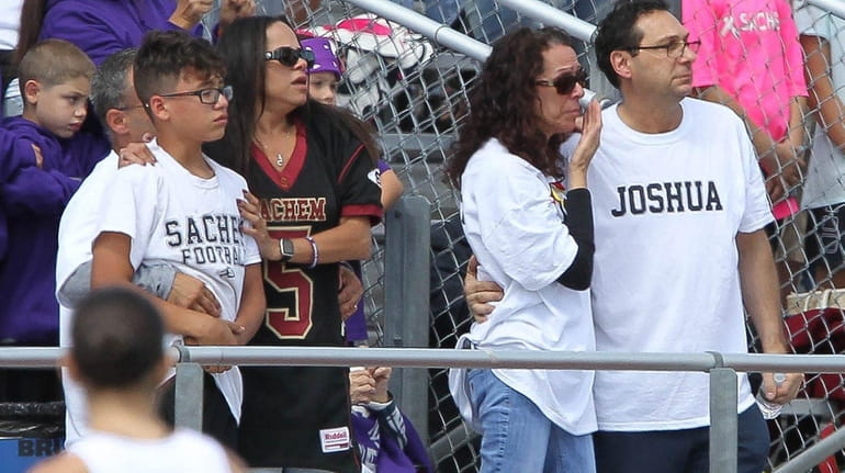 The family of Sachem East's Josh Mileto console one other...