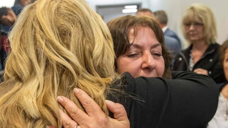 Diane Cusick's daughter Darlene Altman hugs Nassau County District Attorney Anne Donnelly...