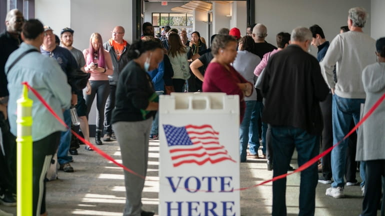 People are seen in line to vote on the first...