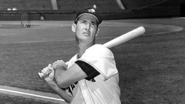 Ted Williams of the Boston Red Sox swings a bat...