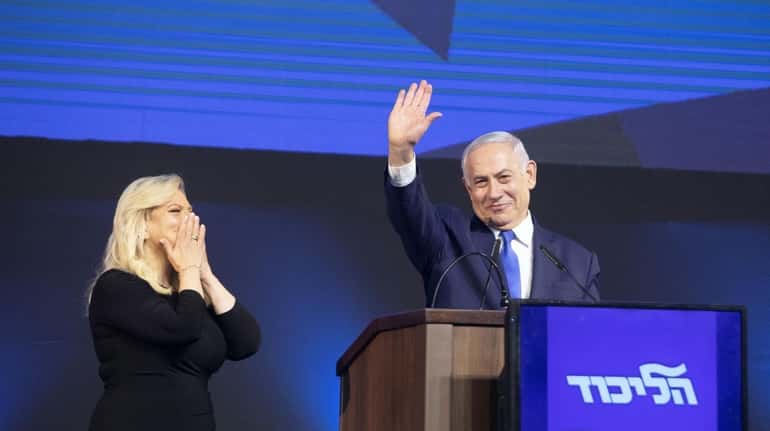Israeli Prime Minister Benjamin Netanyahu waves as wife Sara Netanyahu...