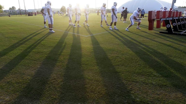 Tennessee Titans players cast shadows in the setting sun during...
