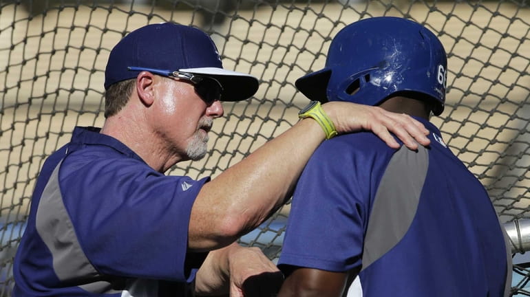 Los Angeles Dodgers batting coach Mark McGwire, left, talks with...