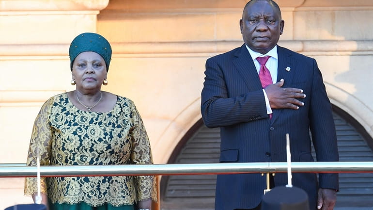 South African President Cyril Ramaphosa gestures while standing next to...