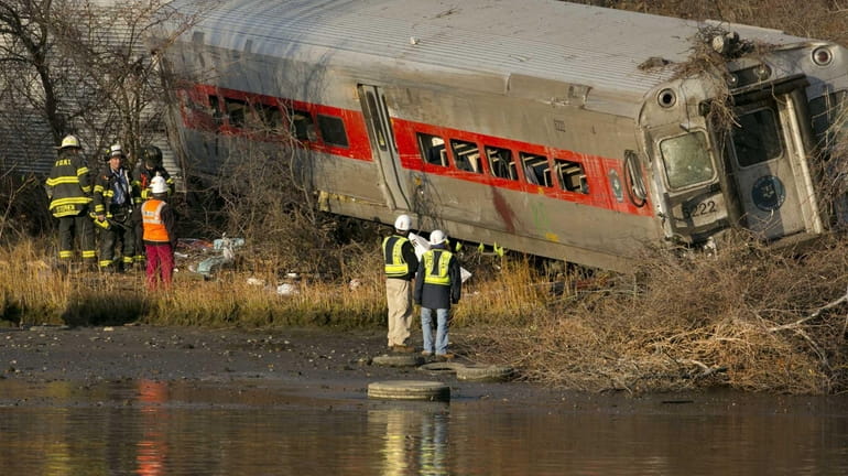 Officials with the National Transportation Safety Board inspect the derailed...