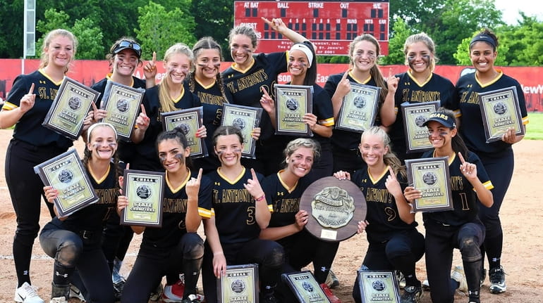 St. Anthony's softball players pose with their championship plaques after defeating Molloy...