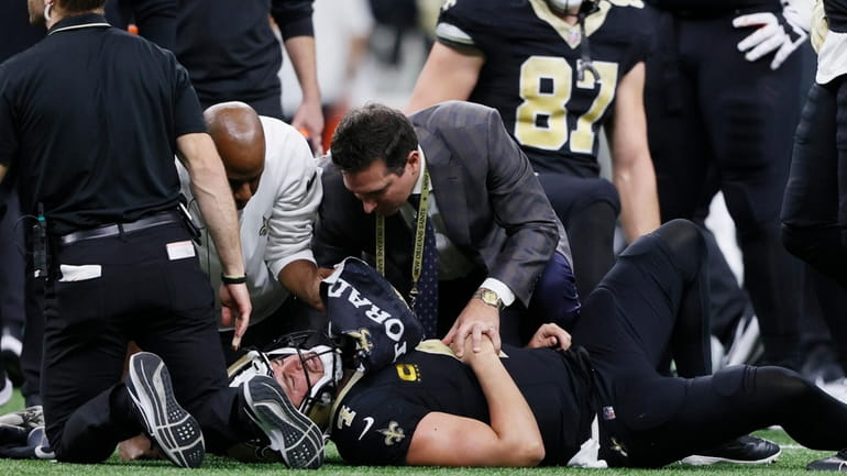 Medical personnel look over New Orleans Saints quarterback Derek Carr...
