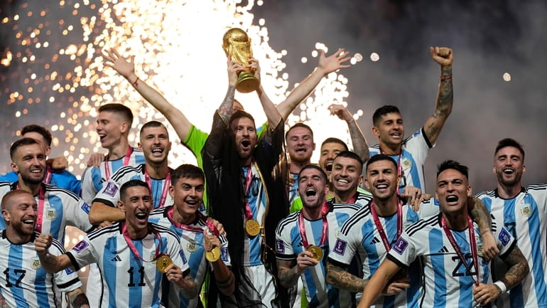 FILE - Argentina's Lionel Messi lifts the trophy after winning...