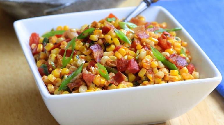 Corn and tomatoes are cooked in a skillet and tossed...