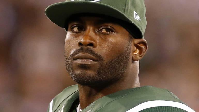 Michael Vick #1 of the Jets looks on during a...