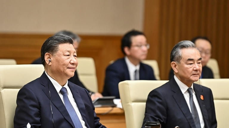 China's President Xi Jinping, left, and Foreign Minister Wang Yi...