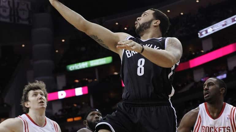 Brooklyn Nets' Deron Williams goes up for a shot between...