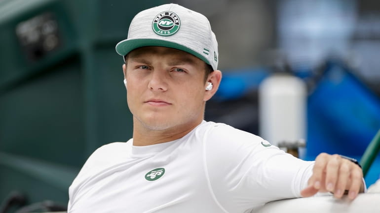 Jets quarterback Zach Wilson sits on the bench during warm-ups...