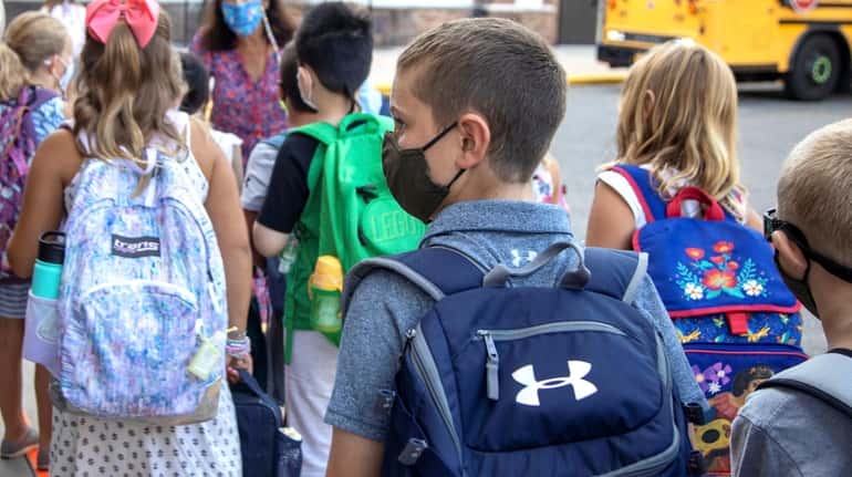 Elementary school students wear masks in September 2020 upon their...