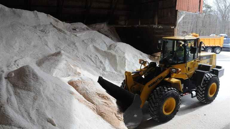A Suffolk County Department of Public Works bulldozer moves salt...