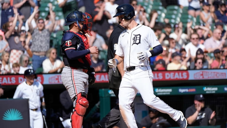 Detroit Tigers' Mark Canha, right, scores as Minnesota Twins catcher...