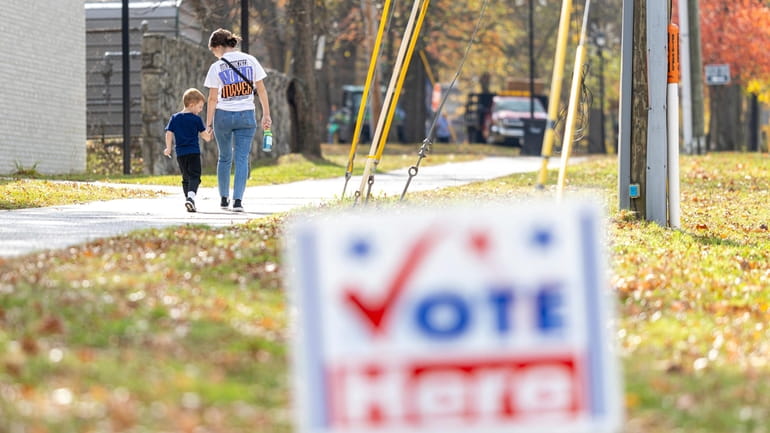 A mother and her son exit a polling place on...