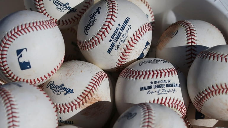 In this Feb. 14, 2020, file photo, baseballs sit in...