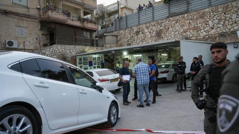 Israeli police examine the scene of a shooting where a...