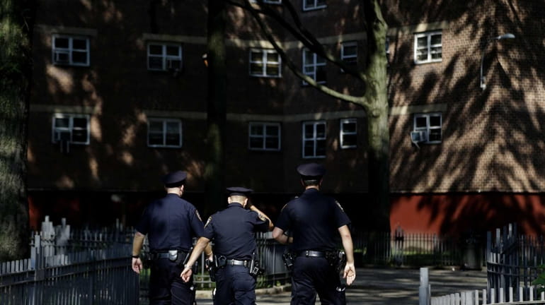 Police officers walk through the Brownsville Houses the Brownsville section...