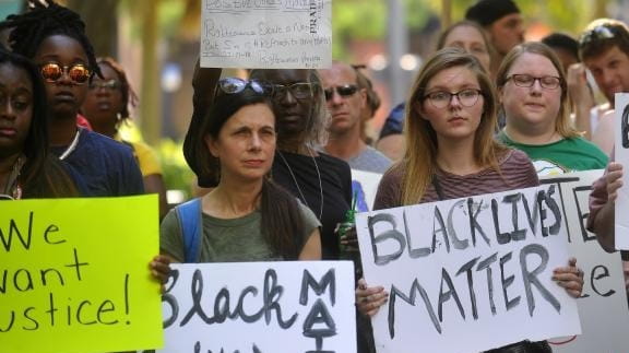 Protesters hold signs during a Black Lives Matter movement protest...