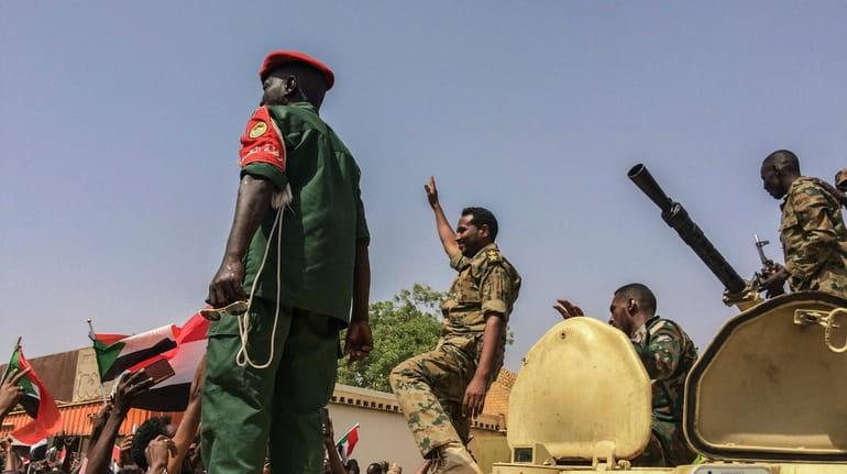 Sudanese forces celebrate on Thursday after officials said the military...
