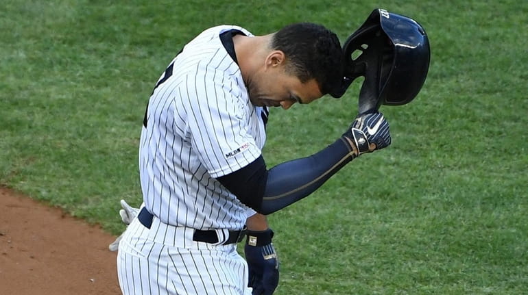 Giancarlo Stanton reacts after he strikes out to end the...