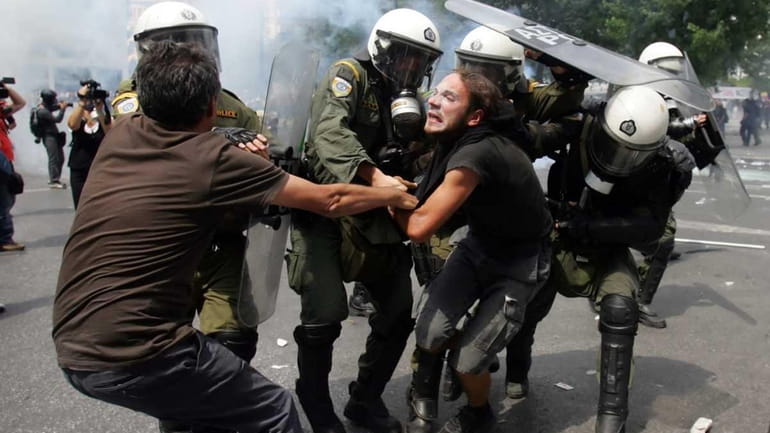 Riot police arrest demonstrators as they clash with police during...