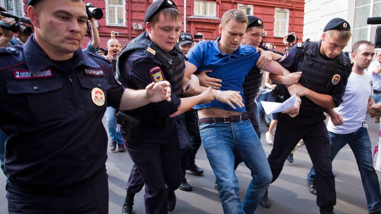 Police officers detain Russian opposition leader Alexei Navalny, center, in...