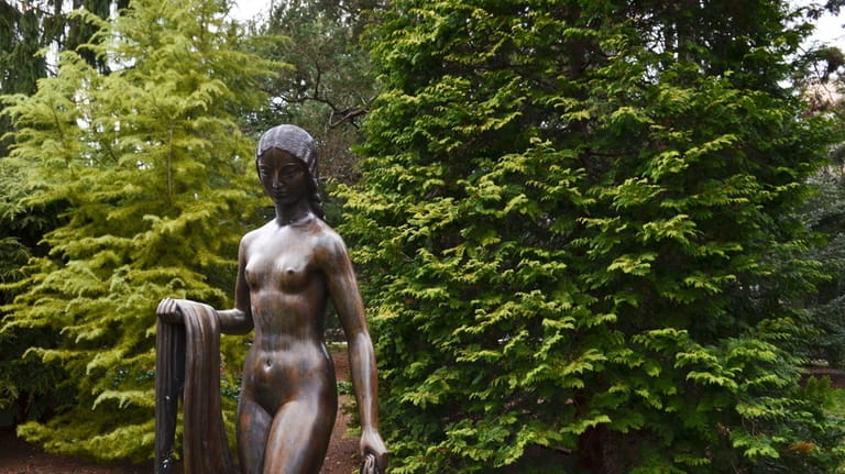 A statue greets visitors at the entrance of a Pinetum...