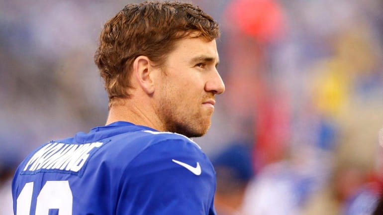 Eli Manning of the Giants looks on from the sidelines...