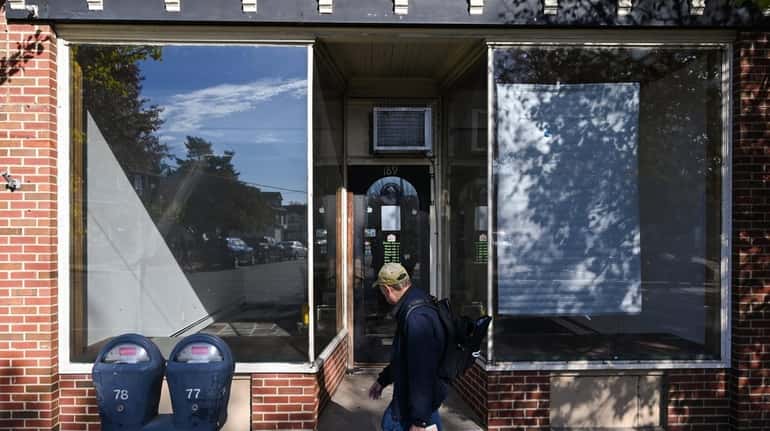 A person passes a storefront that recently housed Computer Port...