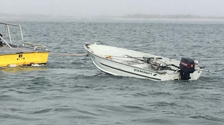 A disabled boat is towed in Moriches Inlet on Friday,...