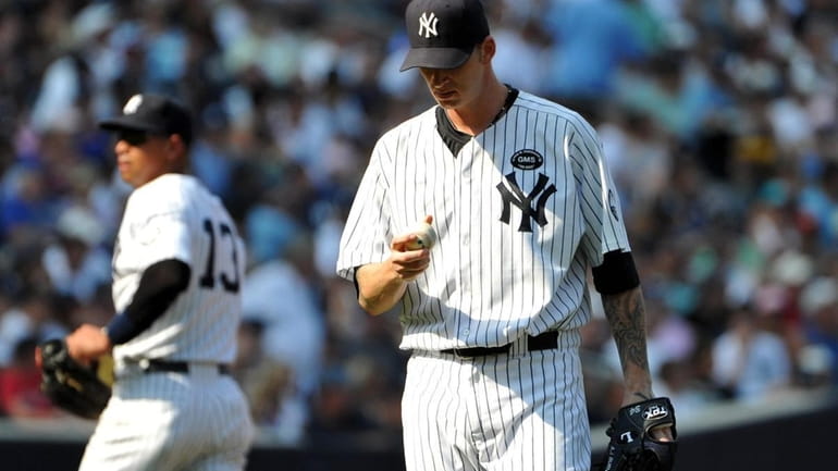 Yankees starting pitcher A.J. Burnett looks at his hand while...