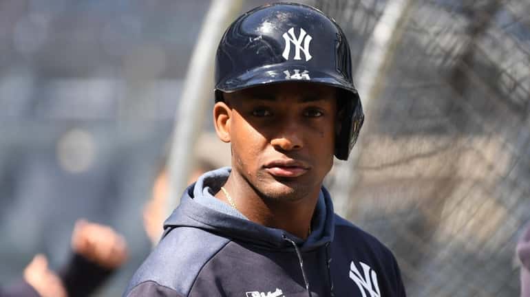 The Yankees' Miguel Andujar looks on by the batting cage...