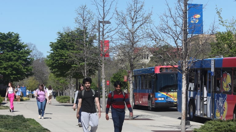 Students walk down Jayhawk Boulevard, the main street through the...