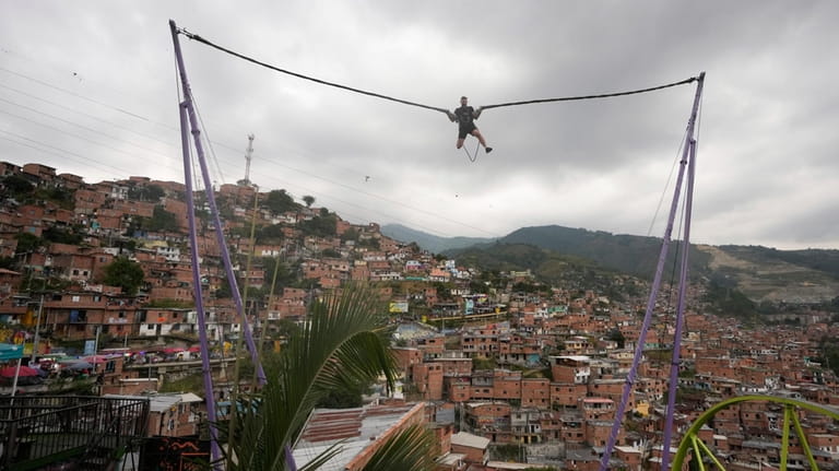 A tourist rides a bungee jump in the Comuna 13...