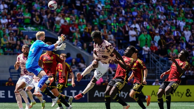 Seattle Sounders goalkeeper Stefan Frei, left, goes up to defend...