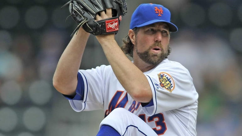R.A. Dickey winds up to pitch during a game against...