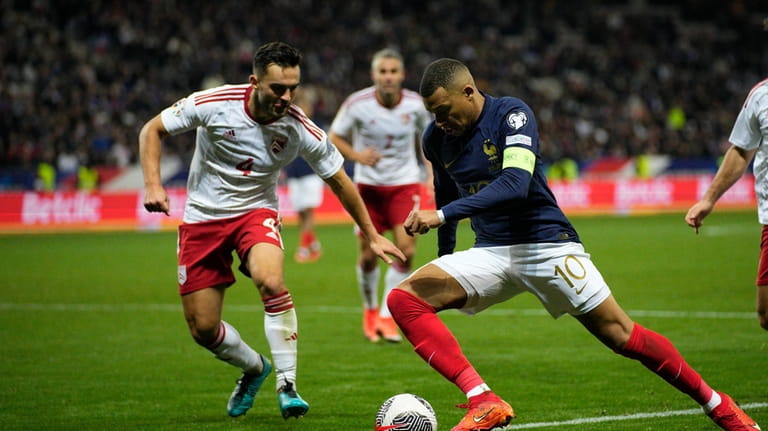 France's Kylian Mbappe, centre, is in action during the Euro...