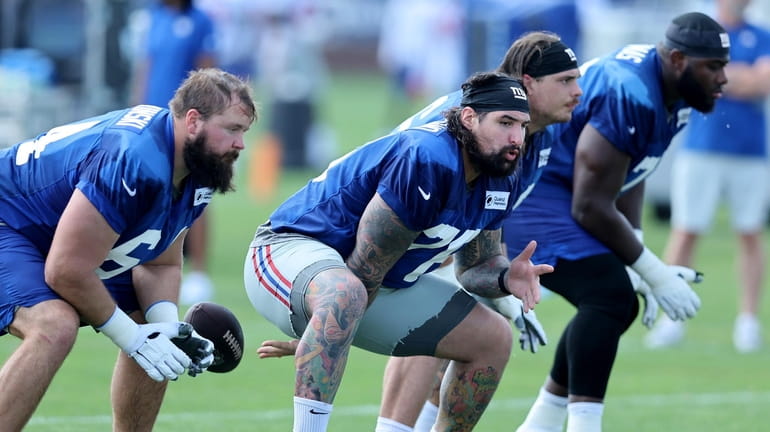 Giants offensive lineman Jon Feliciano snaps the ball during training...