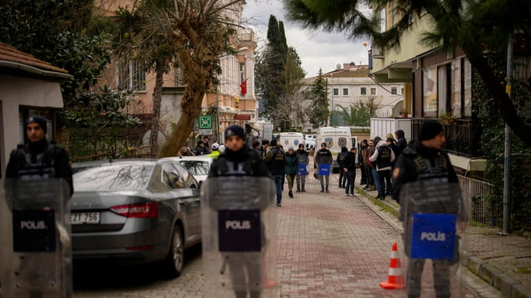 Turkish police officers stand guard in a cordoned off area...