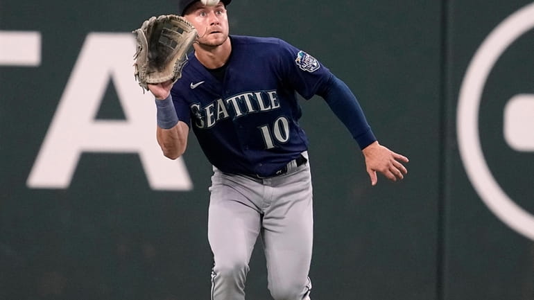Seattle Mariners left fielder Jarred Kelenic reaches up to catch...