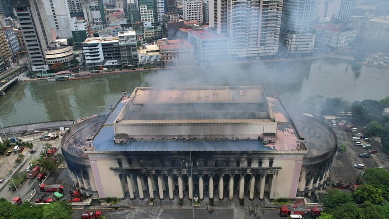 Smoke billows from the still smoldering Manila Central Post Office...
