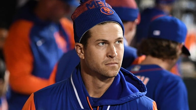Mets pitcher Jacob deGrom looks on from the dugout in...