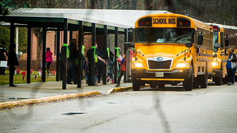 Students leave a school bus during the first day back...